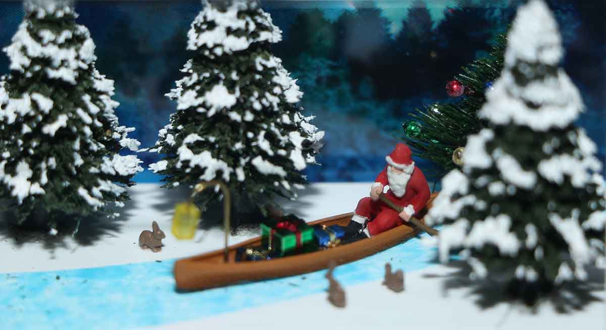 Weihnachtsmann auf Kanu im Winterwald auf der Modellbahn